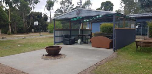a gazebo with a bench and a table at Grampians View Cottages and Units in Halls Gap