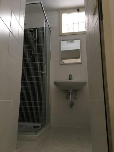 a bathroom with a sink and a glass shower at Medieval terraced house in Vieste Vecchia in Vieste