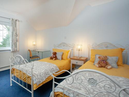 two beds in a room with two teddy bears on them at Gratton House in Whitestone
