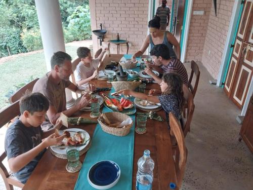 a group of people sitting at a table eating food at Ella Nine Peaks in Ella