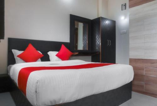 een slaapkamer met een groot bed met rode kussens bij Hotel Shanti Heritage, Guna in Guna