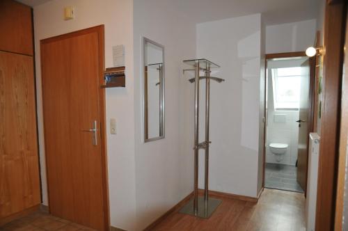 een badkamer met een douche, een toilet en een deur bij Haus Jodokus, Whg Professor Paljass in Kellenhusen
