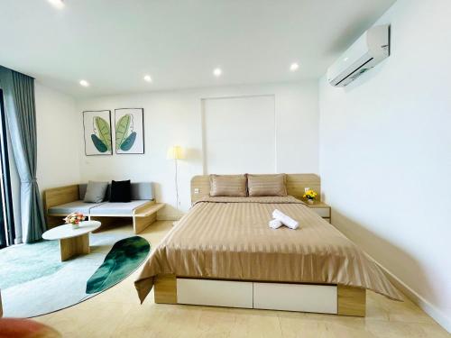 um quarto com uma cama e um sofá em Vinhomes Dcapitale - Studio em Hanói