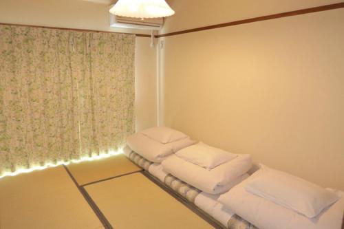 Habitación con 3 almohadas en un estante en Aoisora Aoiumi no guest house - Vacation STAY 75101v, en Takamatsu