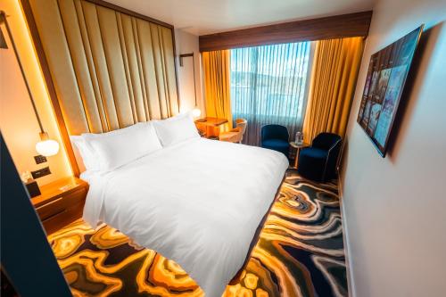 a hotel room with a white bed and a window at FIVE Zurich - Luxury City Resort in Zurich