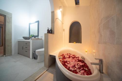 a bathroom with a bath tub filled with flowers at Villa Sayang Sanur 111 in Sanur