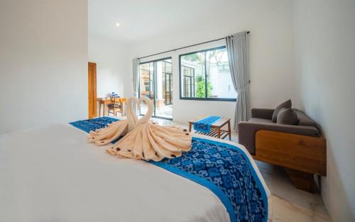 a bedroom with a large bed and a living room at Villa Sayang Sanur 111 in Sanur