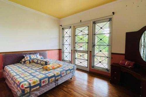 En eller flere senge i et værelse på Villa Desa by CozyVilla at Puncak Resort