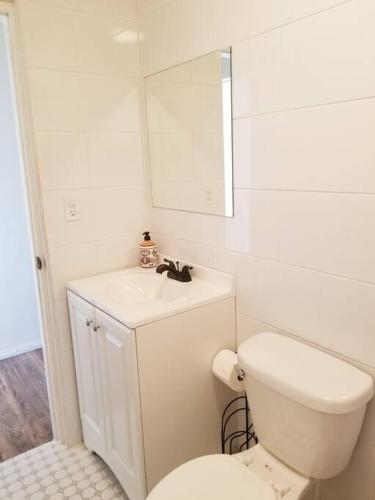 a bathroom with a toilet and a sink and a mirror at Tu Casa de Familia in Tijuana