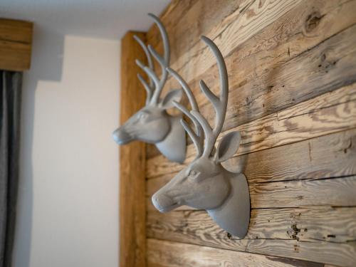 a wall with two deer heads on it at Alpine Lodge Brixen in Brixen im Thale