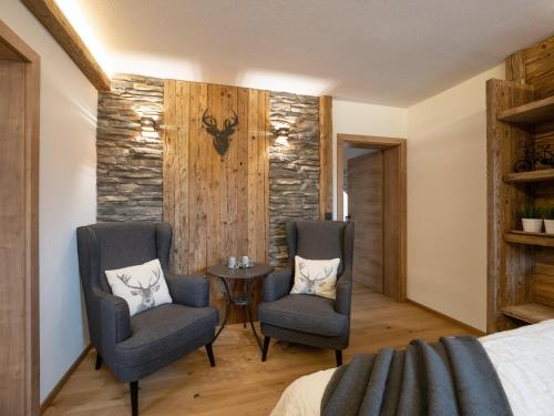 a bedroom with two chairs and a table in a room at Alpine Lodge Brixen in Brixen im Thale