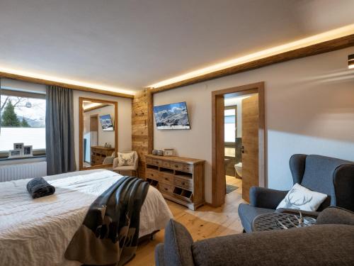 a bedroom with a bed and a tv on the wall at Alpine Lodge Brixen in Brixen im Thale
