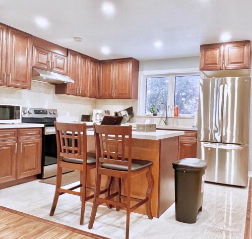 a kitchen with wooden cabinets and a stainless steel refrigerator at Spacious Rooms with Bath Near Wonderland & Vaughan Mills Mall in Vaughan
