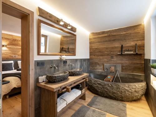 a bathroom with two sinks and a large stone tub at Alpine Lodge Brixen in Brixen im Thale
