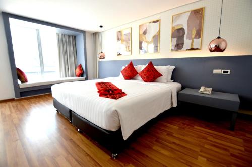 a bedroom with a large bed with red pillows at I Residence Hotel Silom in Bangkok
