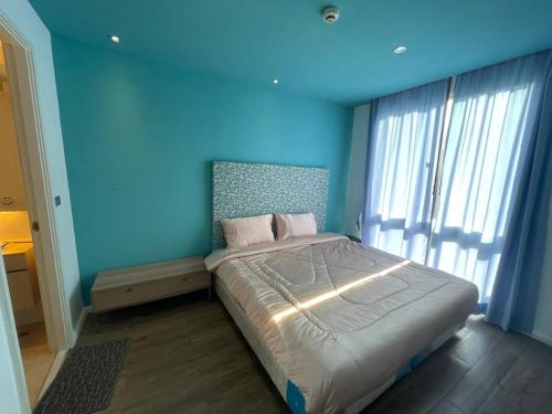 a blue bedroom with a bed with a blue wall at Atlantis Condo Resort Pattaya KPC7 in Pattaya South
