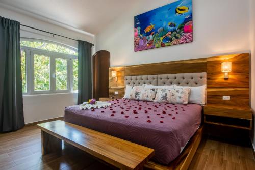 Un dormitorio con una cama grande con rosas rojas. en Villa Golf Holiday Private Pool, Barbecue, Family Friendly, Golf Course en Playa del Carmen