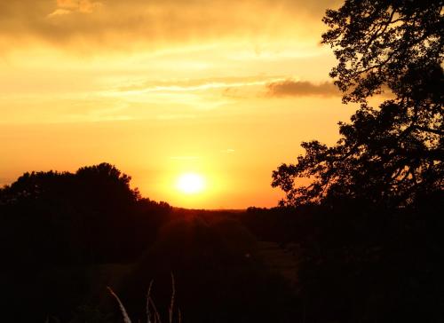 a sunset with the sun setting in the distance at Gîtes à l'ombre des chênes in Châteauvieux
