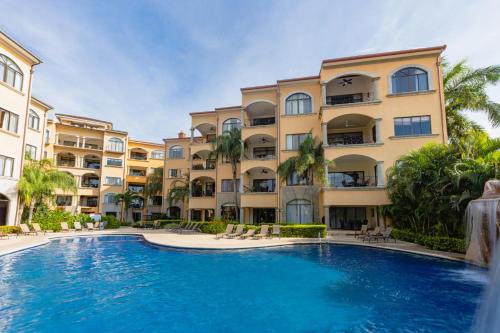 a swimming pool in front of a building at Sunrise 6- Ocean View 2 Br Condo, Steps To The Beach in Tamarindo