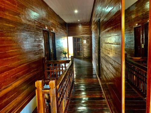 a hallway with wooden walls and stairs in a building at Une Jai Place เรือนอุ่นใจ in Pi Mai