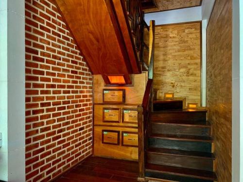 a brick hallway with a staircase and a brick wall at Une Jai Place เรือนอุ่นใจ in Pi Mai