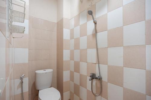 a bathroom with a toilet and a shower at Urbanview Hotel Jagakarsa by RedDoorz in Jakarta