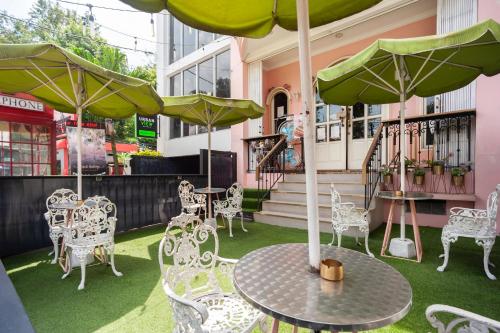 a table and chairs with umbrellas on a patio at Urbanview Hotel Jagakarsa by RedDoorz in Jakarta