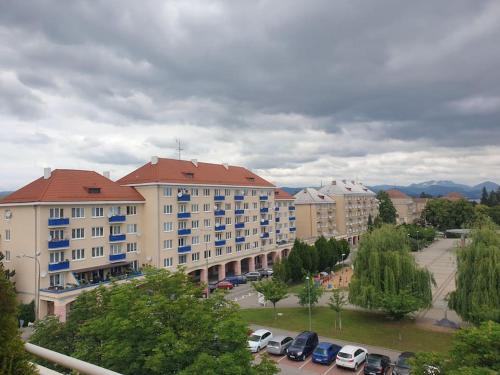 a large building with cars parked in a parking lot at Mezonetovy Apartmán v centre Novej Dubnice in Ilava