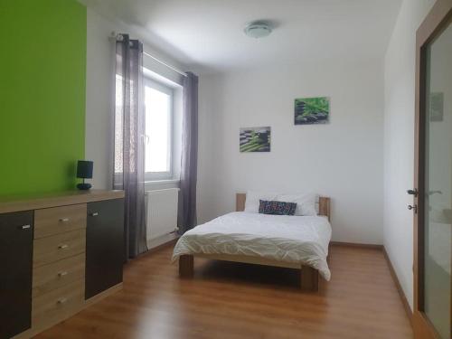 a bedroom with a bed and a dresser and a window at Mezonetovy Apartmán v centre Novej Dubnice in Ilava