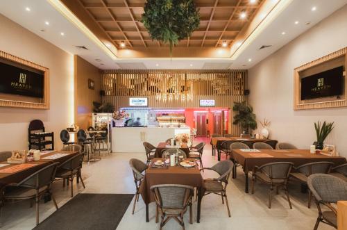 un ristorante con tavoli, sedie e un bancone di Heaven Boutique Hotel a Bangkok