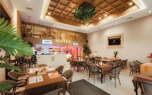 un ristorante con tavoli e sedie e un bar di Heaven Boutique Hotel a Bangkok
