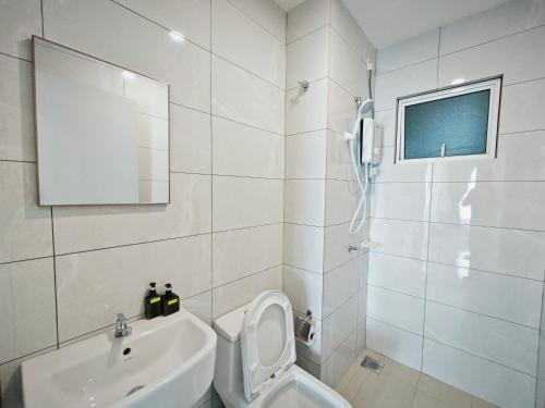 ein weißes Bad mit einem WC und einem Waschbecken in der Unterkunft Balinese Seaview Trevor Amber Suite in Malakka