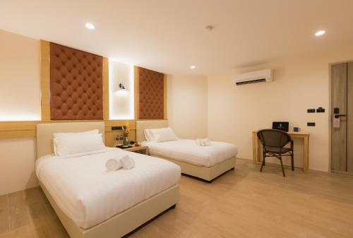 a hotel room with two beds and a desk at Heaven Boutique Hotel in Bangkok