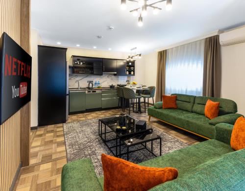 uma sala de estar com sofás verdes e uma cozinha em BayMari Suites City Life em Istambul