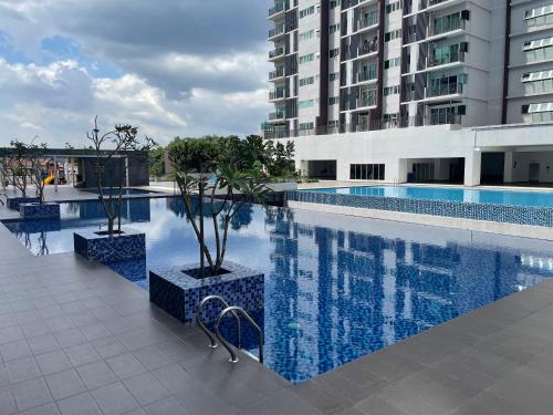 a swimming pool with trees and a building at Premium Service Appartment in Seri Kembangan