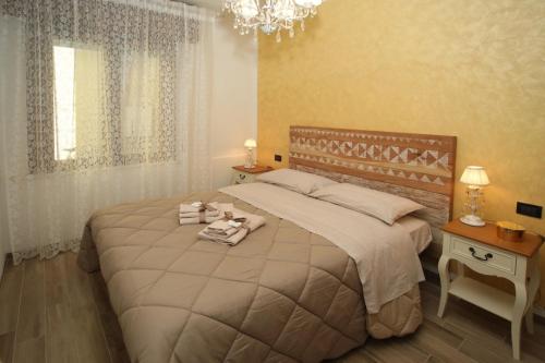 een slaapkamer met een groot bed en een kroonluchter bij Civico 26 in Rimini