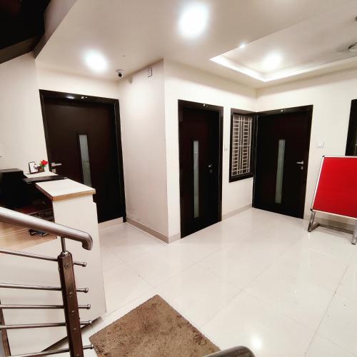 a living room with black doors and white floors at Abu Inn, Mount Abu - The Luxury Boutique Stay in Mount Ābu