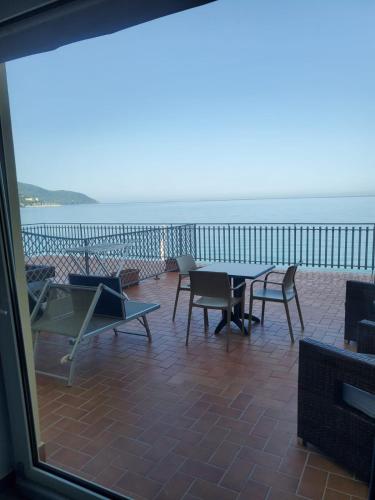a balcony with a table and chairs and the ocean at Hotel Residence La Darsena in Agropoli
