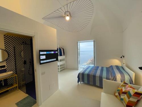 1 dormitorio con 1 cama, TV y sofá en La Pigolina, en Positano