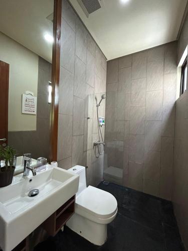 a bathroom with a white toilet and a sink at Villa Vimala Hills Semeru in Bogor