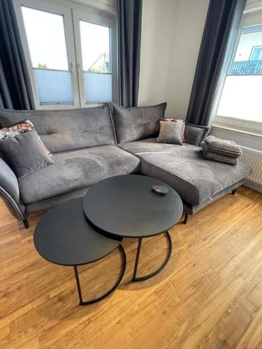 a living room with a couch and two tables at Südschleife Appartements - App. 2 - WLAN - Direkt am Ring in Reimerath