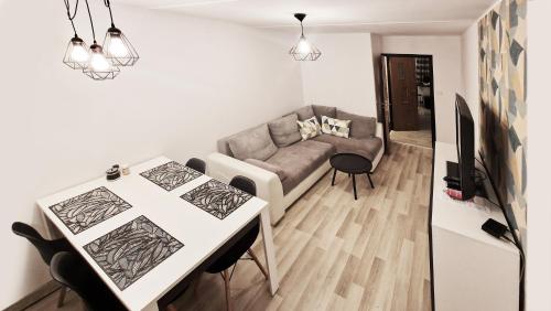 a living room with a couch and a table at Apartament Zakątek - Centrum in Szklarska Poręba