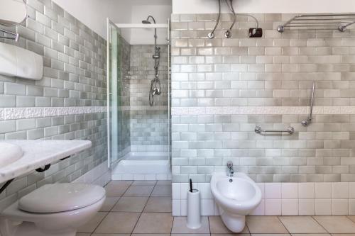 y baño con ducha, aseo y lavamanos. en Locanda di Corte en Bosa