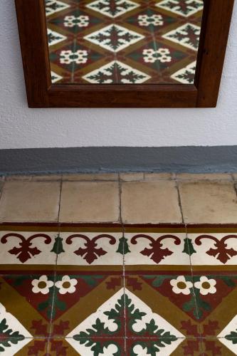 a tiled floor with a mirror on a wall at Locanda di Corte in Bosa