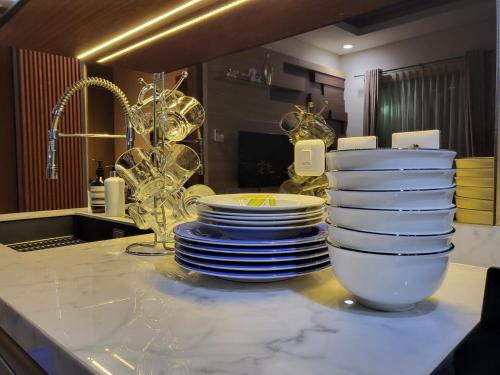 un tas de assiettes et de bols sur un comptoir de cuisine dans l'établissement Villa Vimala Hills Semeru, à Bogor