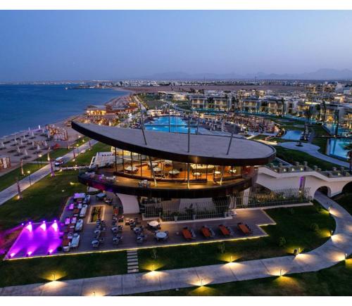 a view of a building with a pool at night at Rixos Premium Magawish Suites and Villas- Ultra All-Inclusive in Hurghada