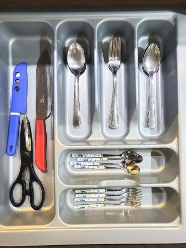 a tray with silver utensils in a drawer at Villa Vimala Hills Semeru in Bogor