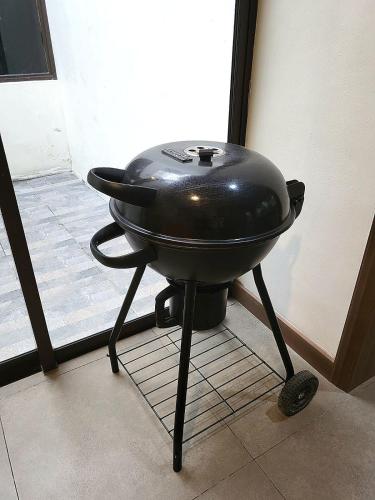 a black barbecue grill sitting on a tiled floor at Villa Vimala Hills Semeru in Bogor