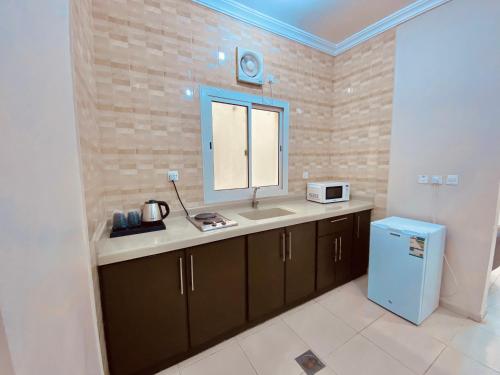 a kitchen with a counter and a sink and a window at فلورز سويتس in Yanbu