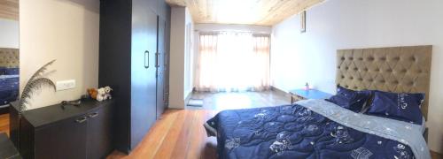 a bedroom with a bed with a blue comforter and a window at Hello Home in Pelling